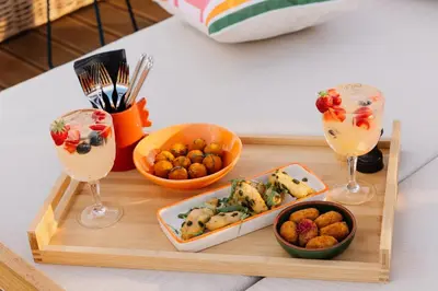 a wooden tray with food and two glasses of wine at AC Hotel by Marriott Nice in Nice