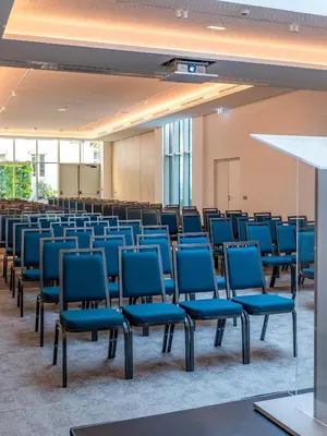 an empty room with blue chairs in a classroom at AC Hotel by Marriott Nice in Nice