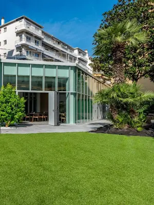 a building with a green lawn in front of it at AC Hotel by Marriott Nice in Nice