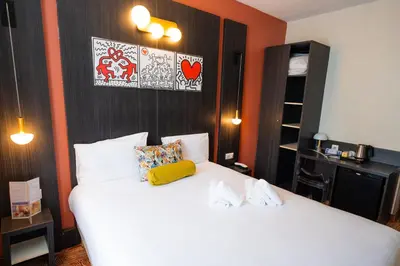 a bedroom with two white beds and orange walls at Hôtel Le Seize, Nice Centre in Nice