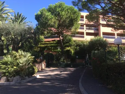 a street with trees and a building in the background at AZURELLE in Nice