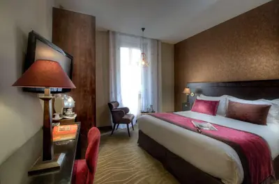 a hotel room with a large bed and a lamp at Best Western Plus Nice Cosy Hotel in Nice