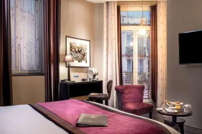 a hotel room with a bed and a desk and a window at Best Western Plus Nice Cosy Hotel in Nice