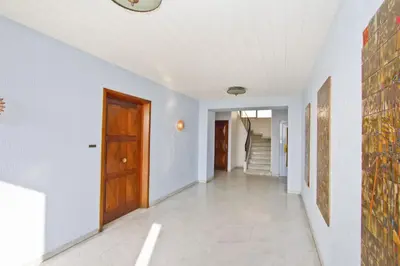 a hallway with white walls and a wooden door at PROMENADE HOLIDAY - CARIATIDE PROMENADE SEA VIEW in Nice