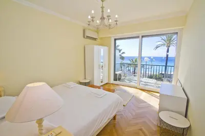 a room with two beds and a view of the ocean at PROMENADE HOLIDAY - CARIATIDE PROMENADE SEA VIEW in Nice