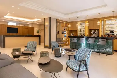 a hotel room with a bed and a chair at Hôtel Apollinaire Nice in Nice