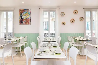 a dining room with white tables and white chairs at Hotel Florence Nice in Nice