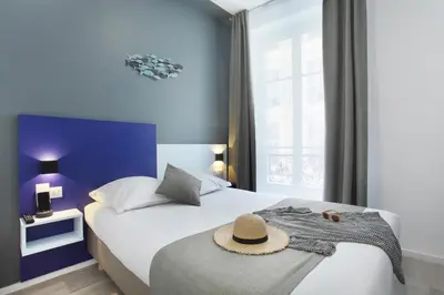 a hotel room with a bed with a hat on it at Hôtel Alcôve Nice in Nice