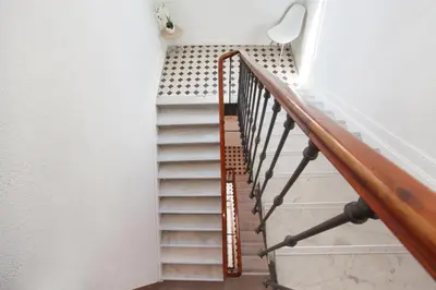a stairway with a wooden rail and a stair case at Hôtel Alcôve Nice in Nice