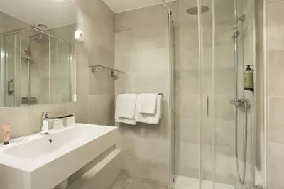 a bathroom with a sink and a shower at Hôtel Alcôve Nice in Nice
