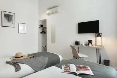 a bedroom with a bed with a hat and a desk at Hôtel Alcôve Nice in Nice