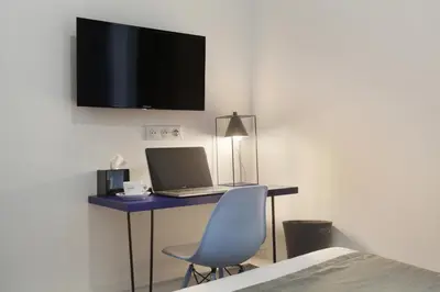 a room with a desk with a laptop and a chair at Hôtel Alcôve Nice in Nice