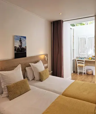 a hotel room with a bed and a large window at Hôtel de la Fontaine in Nice