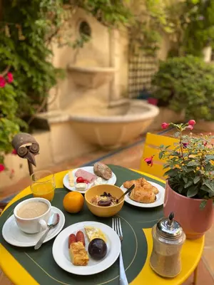 a table with plates of breakfast food on it at Hôtel de la Fontaine in Nice