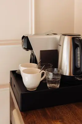 a coffee maker and two cups on a counter at Hotel Ambassador, completely renovated in Nice
