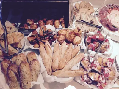 a table filled with different types of pastries and bread at Hotel Suisse in Nice