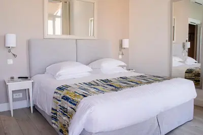 a bedroom with a large bed and a mirror at Hotel Suisse in Nice