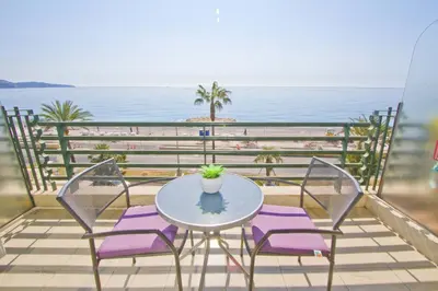 a table and chairs on a balcony with the beach at LES MOUETTES - PROMENADE HOLIDAY in Nice