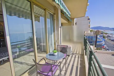 a balcony with a table and chairs on a building at LES MOUETTES - PROMENADE HOLIDAY in Nice