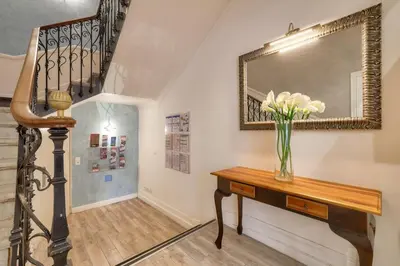 a staircase with a vase of flowers on a table and a mirror at Hotel Lepante in Nice