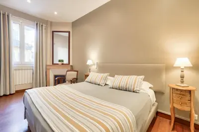 a bedroom with a large bed and a table with a chair at Hotel Lepante in Nice