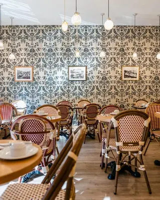 a dining room with tables and chairs and wallpaper at Hotel Le Grimaldi by Happyculture in Nice