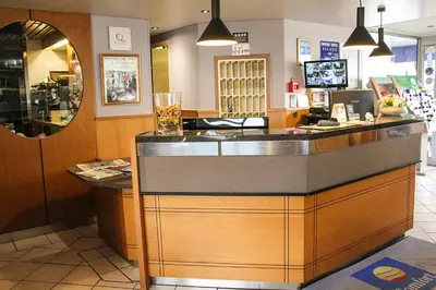 a restaurant with a counter in a store at The Originals City, Hôtel Galaxie, Nice Aéroport in Saint-Laurent-du-Var