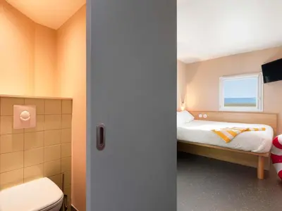 a small bedroom with a bed and a window at Greet Hotel Nice Aéroport Promenade des Anglais in Nice