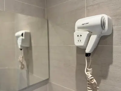 a hair dryer is attached to a wall in a bathroom at Trocadero in Nice