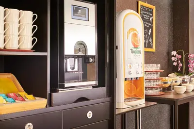a kitchen with a refrigerator next to a counter at Campanile Hotel Nice Centre Acropolis in Nice