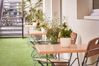 a row of tables and chairs with potted plants at Campanile Hotel Nice Centre Acropolis in Nice