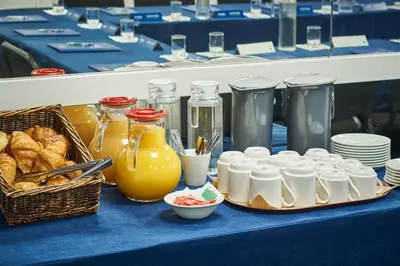 a table with food and drinks and a basket of bread at Campanile Hotel Nice Centre Acropolis in Nice