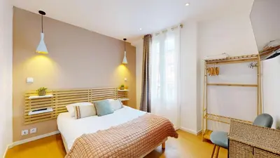 a bedroom with a white bed and a window at Hotel Solara in Nice