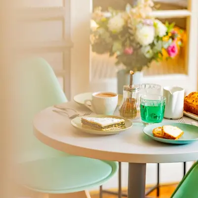 a table with two plates of food and a cup of coffee at Hotel Aria in Nice