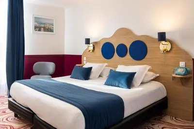 a bedroom with a large bed with a wooden headboard at Best Western Hotel Lakmi Nice in Nice