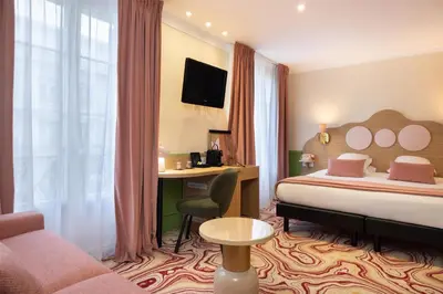 a hotel room with a bed and a desk at Best Western Hotel Lakmi Nice in Nice