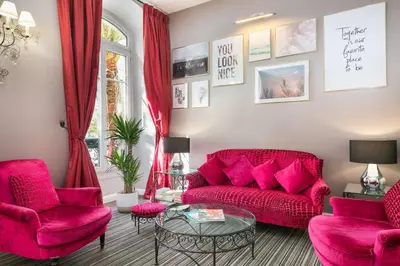 a living room with red couches and a glass table at Best Western Hotel Lakmi Nice in Nice