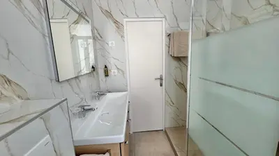 a white bathroom with a sink and a mirror at Hôtel Helvétique in Nice