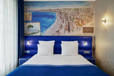 a bed with a blue headboard with a painting above it at Nice Excelsior Centre ville by HappyCulture in Nice