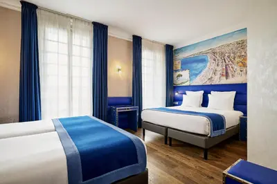 a hotel room with two beds and a painting on the wall at Nice Excelsior Centre ville by HappyCulture in Nice