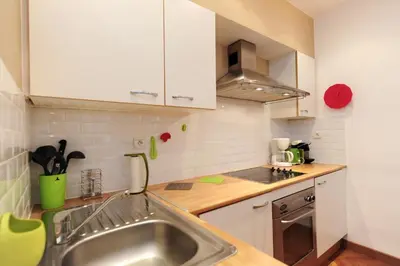 a kitchen with a stainless steel sink and white cabinets at Le Savoy Palace - Five Stars Holiday House in Nice