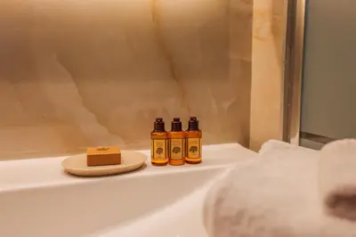 three bottles of essential oils sitting on a shelf in a bathroom at AzurAppart Brilliant 2room, Nice Massena in Nice
