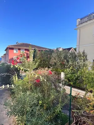 a garden with red flowers and a fence at Studio in the center of Saint-Jean-cap-Ferrat in Saint-Jean-Cap-Ferrat
