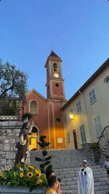 a church with a clock tower in front of a building at Studio in the center of Saint-Jean-cap-Ferrat in Saint-Jean-Cap-Ferrat