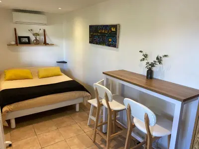 a bedroom with a bed and a table and chairs at Petite chambre indépendante avec sdb, clim et parking privé in Nice