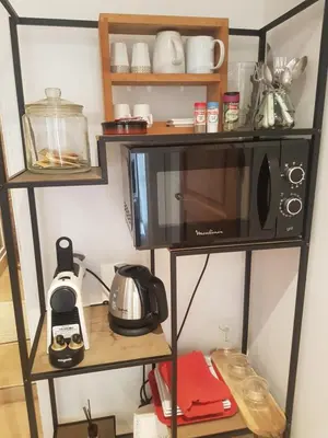 a microwave oven sitting on a shelf in a kitchen at Petite chambre indépendante avec sdb, clim et parking privé in Nice