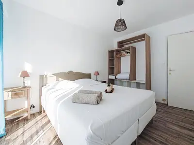 a bedroom with a large white bed and a mirror at Apartment Le Clos tranquille by Interhome in Nice