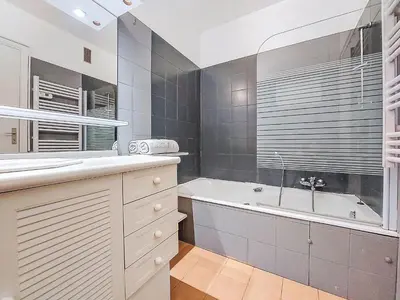 a bathroom with a tub and a sink and a bath tub at Apartment Le Clos tranquille by Interhome in Nice