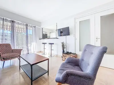 a living room with a chair and a table at Apartment Le Clos tranquille by Interhome in Nice