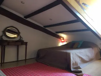 a bedroom with a bed and a mirror in a attic at Garibaldi mansardé in Nice